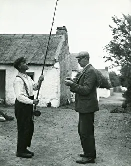 John Barrett and boatman Dick Burke enjoy a tall: fishing story together circa 1947
