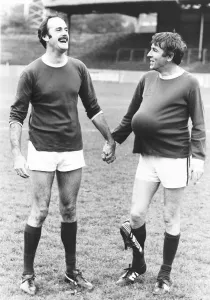 Holding Hands Prints: John Cleese Actor with fellow Actor Peter Cook at a Charity Football Match