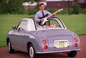 Guitars Prints: JOHN DINGWALL TEST DRIVES ERIC CLAPTONS CAR AUGUST 1997 STANDING UP IN CAR ROOF ROLLED