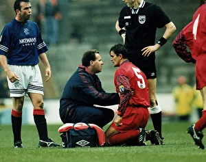 Controversy Prints: John Inglis of Aberdeen kneeling on ground being treated by a physio after a headbutt by