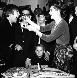 John Lennon being fed birthday cake by Claudette Orbison while her husband Roy