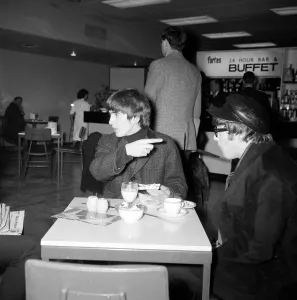 John Lennon and George Harrison of the Beatles pop group smoking cigarettes
