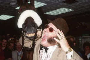 John McCririck horseracing expert and TV presenter stand with Red Rum