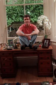 John Stapleton TV Presenter September 1998 At home sitting on his desk
