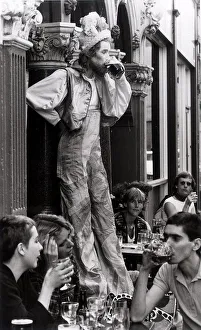 Busker Prints: John Trigger stilt walker stops for a pint of beer in Covent Garden
