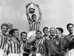 Johnny Dixon the Aston Villa Captain is chaired by team-mates after he has received the F