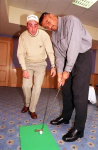 00889 Prints: Jonah Lomu Rugby player October 1999 playing golf putting Receiving lesson from Kevin