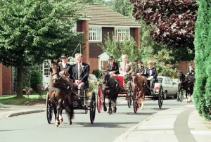 Judges in horse-drawn carriages view the village of Hartlebury, Worcestershire