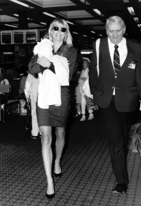 00054 Prints: Kathy Emberg with daughter of Rod Stewart Ruby walking through Heathrow airport
