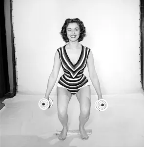 Keep-Fit: Woman exercising with dumb bells. 1960