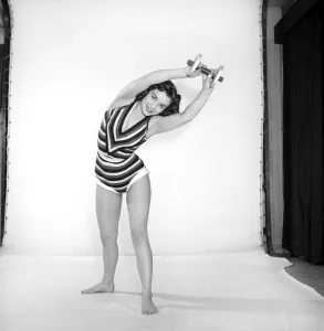 Keep-Fit: Woman exercising with dumb bells. 1960