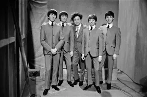 Ken Dodd (centre) posing with Madame Tussauds figures of The Beatles