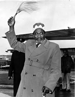 Coat Prints: Kenya - Jomo Kenyatta waves his symbol of office - his fly-whisk - on his arrival
