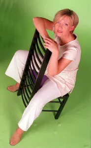 00160 Prints: Kirsty Young TV Presenter Channel 5 sitting on chair wearing white trousers looking up