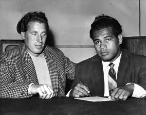 Kitione Lave (Right) and just Burton Sign the contract for their fight. September 1958