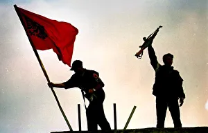 KLA soldiers place flag above a building in Pristina June 1999 PIC BY CHRIS WATT