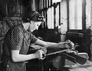 Weapon Prints: A lady working in a munitions factory. She is using what looks to be a bow saw