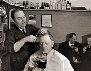 Barbers Prints: The landlord of the Railway Inn, Bernard Fabian cuts hair in between pulling pints in