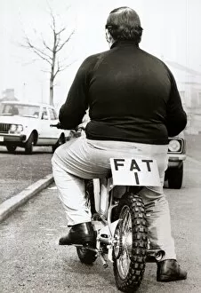 Size Collection: Large man on a small motor cycle with FAT 1 as the licence Number