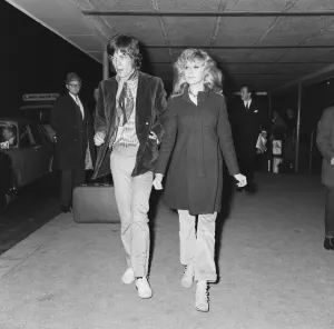 Lead singer of The Rolling Stones pop group Mick Jagger is met by Marianne Faithful