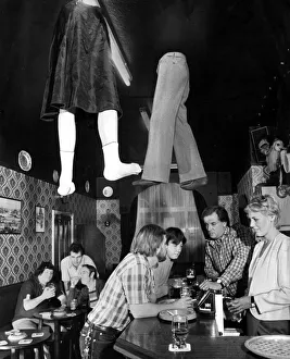 00186 Prints: Legs coming through the roof a local pub as customers order more drinks from the bar