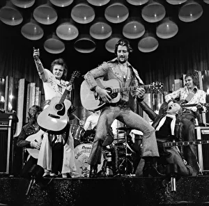 Leicester City footballer Frank Worthington dressed as Elvis Presley supported by