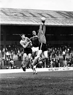 Len Weare, the Newport County goalkeeper jumps high to gather the ball under pressure