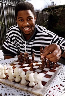 Lennox Lewis Boxing Heavyweight Boxer sitting at table playing chess