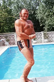 Les Dawson Comedian standing on side of swimming pool at home in St Anne