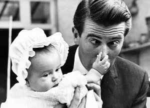 Quirky Prints: Leslie Crowther actor and TV presenter his 4th baby daughter holding his nose