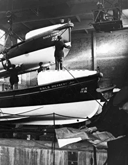 00093 Prints: Lifeboats which have been damaged by coastal gales being overhauled by workmen at a
