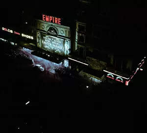 00448 Collection: Lights of london. Empire cinema illuminated as crowds queue to watch the film