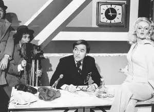 Linda Cunningham Actress Dbase Sitting on table with legs crossed wearing