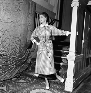 Linda Leigh Fashion Show. Woman poses by the stairs wearing a long check patterned dress