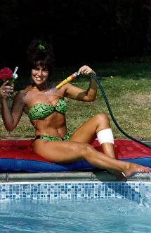 Linda Lusardi Model / TV Presenter sitting by poolside spraying water on to her chest