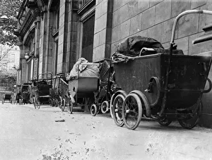 Shelter Prints: A line of prams parked outside a tube station in London as people take cover underground