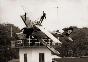 00090 Prints: Lisa Winder 24 stands on top of a Tiger Moth Plane as it flys past the watch tower