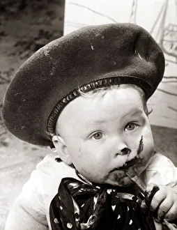 Chocolate Prints: Little boy, eating chocolate in a very messy way. Circa 1950