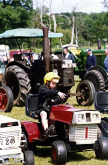 Tractor Prints: A little boy trying our a miniature tractor on show among the traction engines