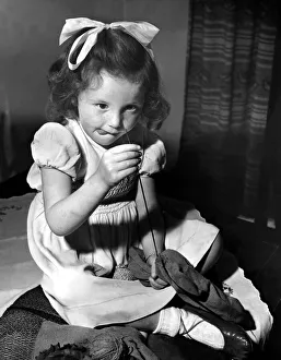 Sewing Prints: Little Hazel Robson of Newcastle, has a go at repairing a hole in a sock
