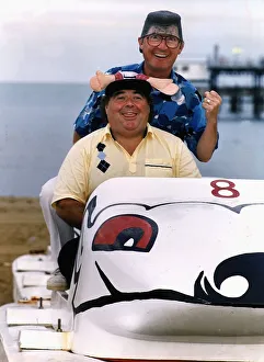 Little & Large Comedy Duo Sitting in toy car on beach wearing funny hat and wig Dbase