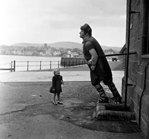 Statue Prints: Little Susan Bond, 4, looks at the wooden figurehead of the Saint George