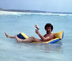 Images Dated 1st June 1978: Liverpool footballer Graeme Souness relaxes reading a book on an inflatable bed