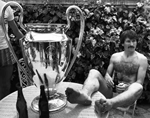 Liverpool footballer Tonny Smith enjoys a bottle of beer as he sits with the famous