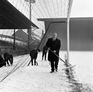 00461 Prints: Liverpool manager Bill Shankly helps to clear the snow from the goal line on the Anfield