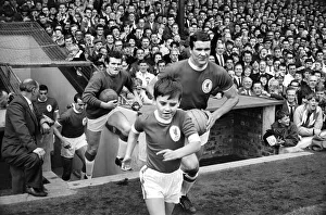 Historic Prints: The Liverpool team run onto the pitch with their young mascot before the English league
