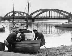 Three People Prints: Local boatmen haul ashore a small rowing boat in Foryd Harbour, Rhyl, Clwyd