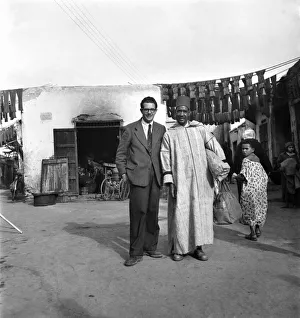 Arabic Prints: Local man f Marrkech, Morocco with European man in the street December 1952