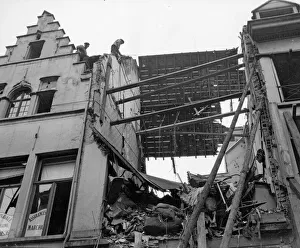 Rooftop Prints: Locals inspect the latest bomb damage in Antwerp the result of one of the three air