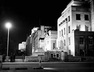 00202 Prints: London by night two policemen stand on a bridge on the Embankment with Shellmex